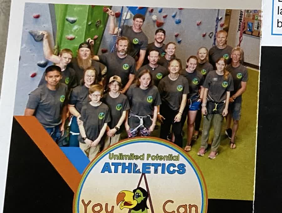 Volunteers and participants gathered at a climbing gym.